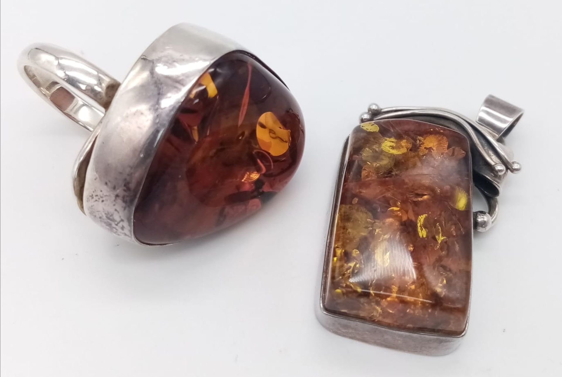 A STERLING SILVER AMBER SET RING. SIZE R & A STERLING SILVER AMBER SET PENDANT. 35.4G IN TOTAL