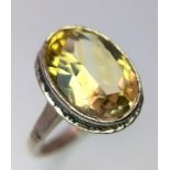 A Vintage Silver and Large Oval Cut Citrine Set Ring Size P. The Ring is set with a 1.5cm Long