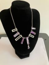 SILVER BELCHER NECKLACE Set with lilac and purple gemstones together with zirconia detail. ‘T’ bar