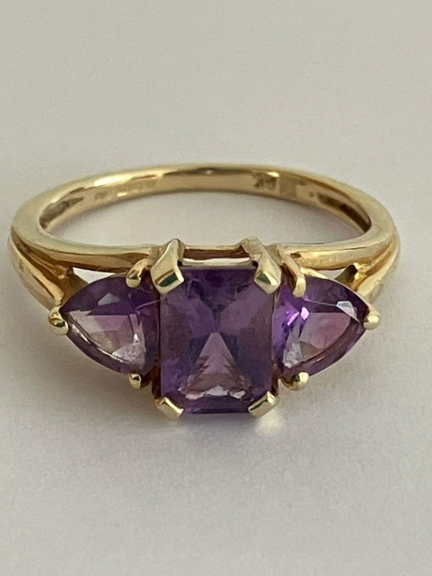 9 carat YELLOW GOLD RING set with AMETHYST GEMSTONES. Mounted in trilogy style, Consisting an (0.