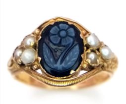 A GEORGIAN 15K GOLD MOURNING RING WITH ORNATE SCROLLING , A HARDSTNE CENTRE STONE AND DECORATED WITH