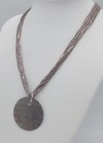 A sterling silver multi-strand chain necklace with a round pendant with the word LOVE in many