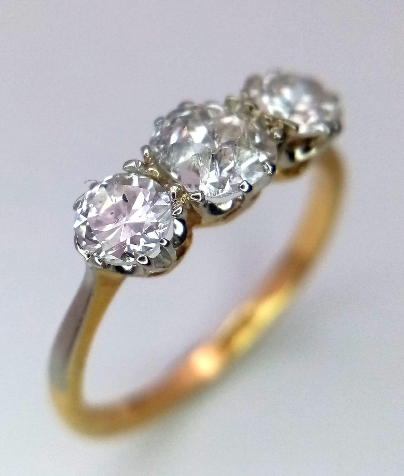 An 18 k yellow gold ring with a trilogy of brilliant round cut diamonds (1 carat min.), ring size: