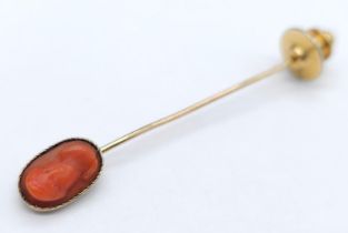 A Victorian Red Coral and Mid-Karat Gold Stickpin. A carved red coral cameo of a Greek/Roman