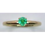 A 9 K yellow gold ring with a single round cut quality emerald standing proud and a halo of diamonds