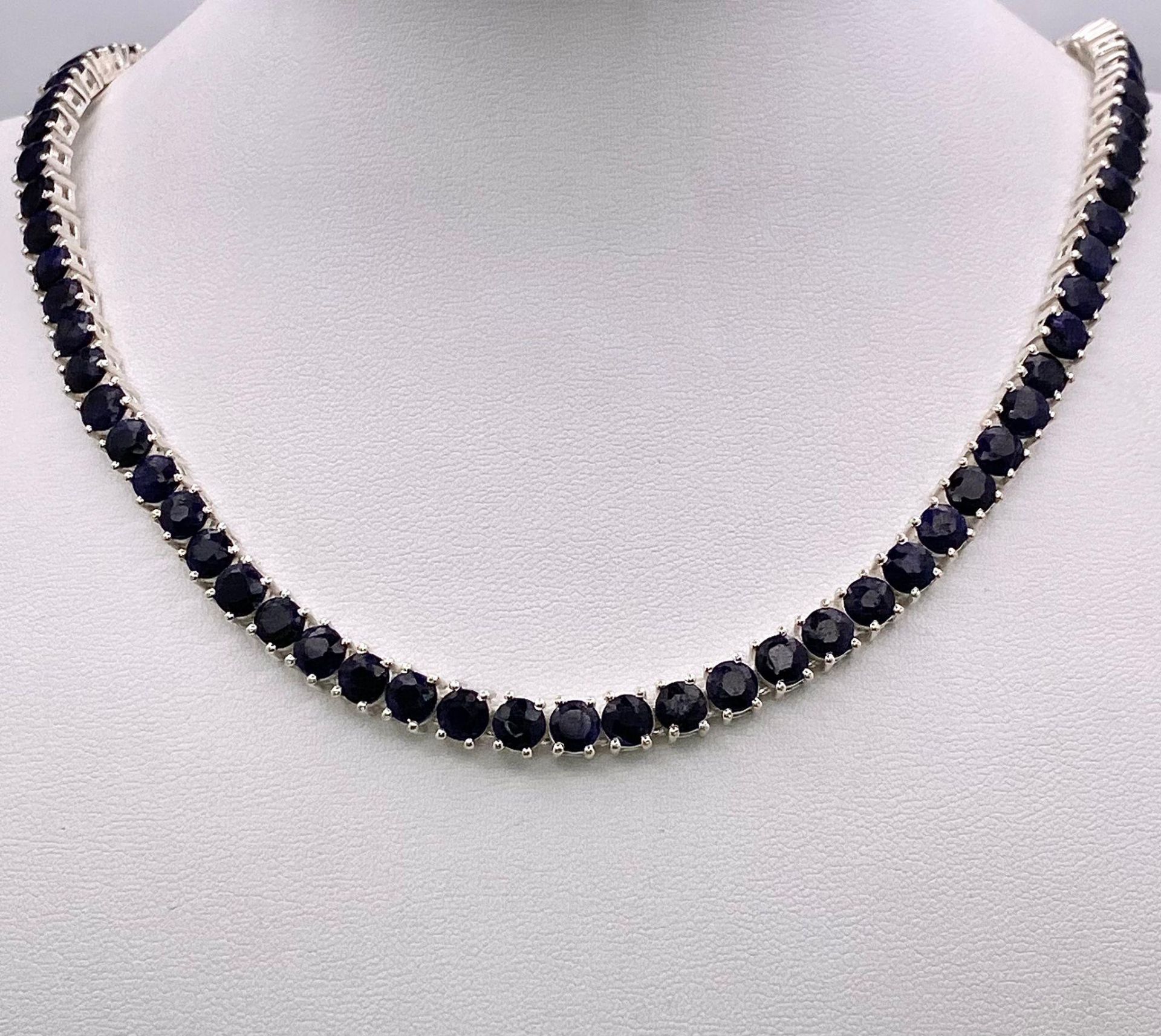 A Blue Sapphire Gemstone Tennis Necklace set in 925 Silver. 45cm length. 40.15g total weight.
