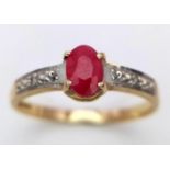 A 9 K yellow gold ring with an oval cut natural ruby and a band of diamonds on each shoulder of