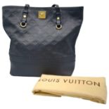 A Louis Vuitton Monogram Empreinte PM Tote Bag. Navy blue exterior with gold tone hardware. Spacious