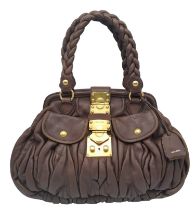 A Miu Miu Brown Leather Handbag. Ruffled leather exterior with two pocketed compartments. Gold