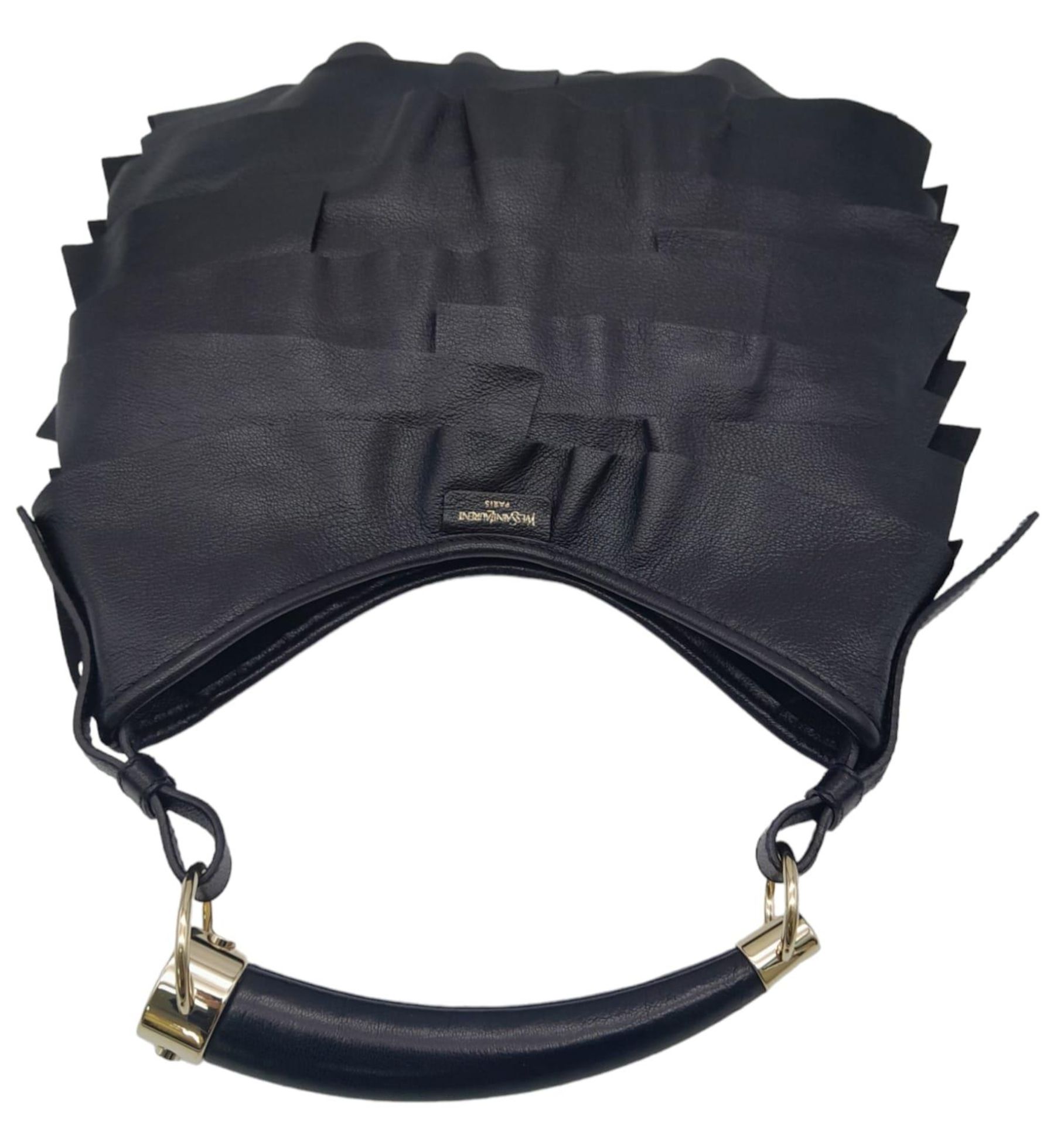 A YSL Saint-Tropez Handbag. Black leather strip exterior. Horn shaped handle. Textile interior - Image 5 of 8