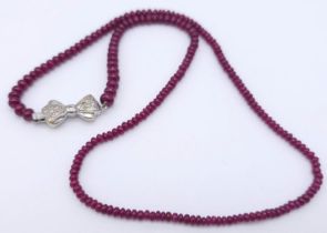 A superb graduating Ruby Red Stone Beaded Necklace with a 18kt White Gold, Diamond Set Bow Clasp.