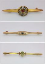 An eclectic small group of three vintage, 9 K yellow gold brooches with gems (diamonds, ruby,
