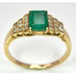 A 9 K yellow gold ring with an emerald cut emerald and round cut diamonds on the solders. Ring size: