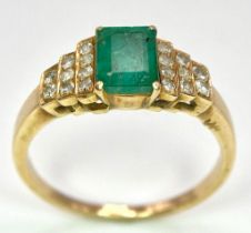 A 9 K yellow gold ring with an emerald cut emerald and round cut diamonds on the solders. Ring size: