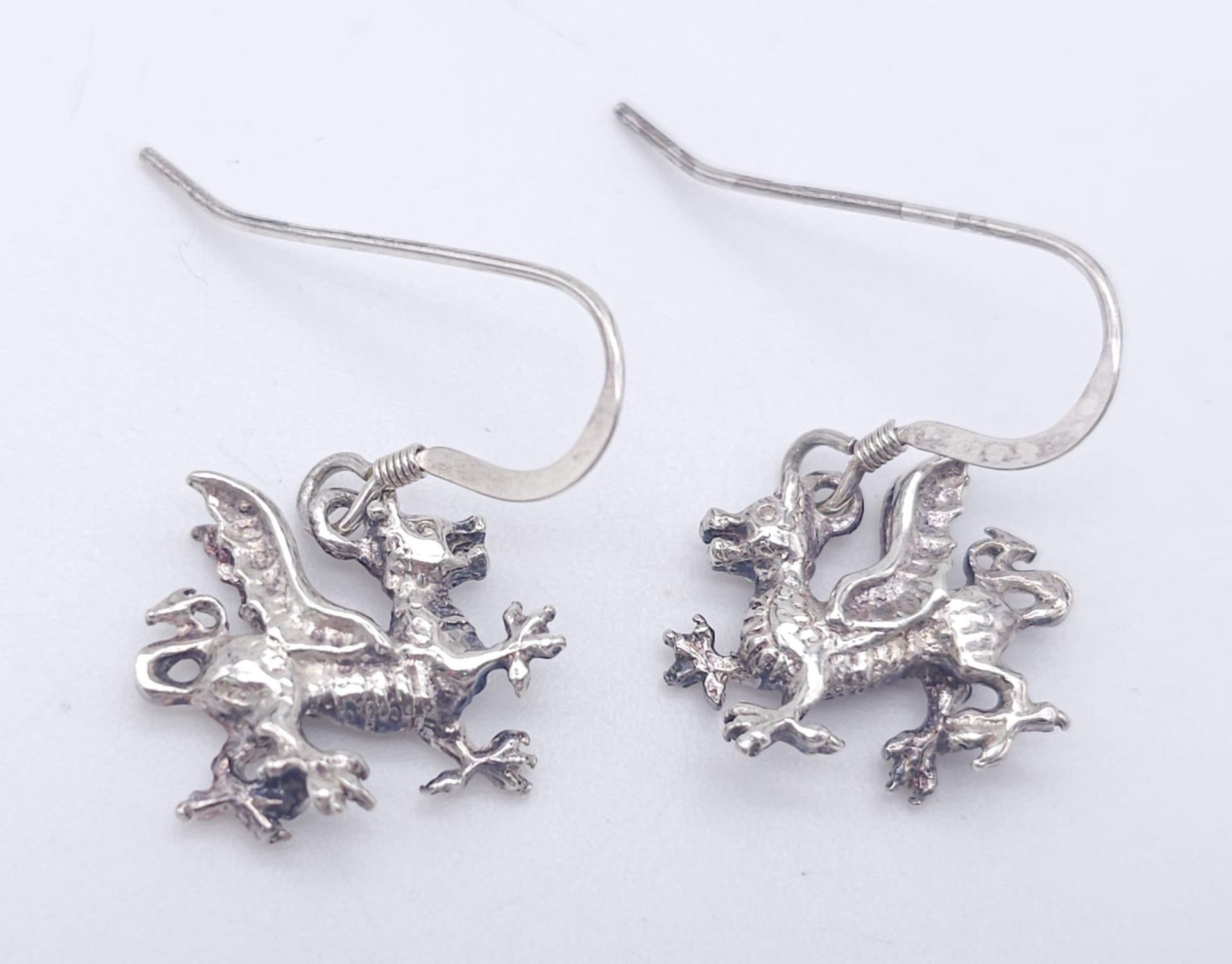 A STERLING SILVER WELSH DRAGON PAIR OF DROP EARRINGS AND MATCHING PENDANT / CHARM. 6.5G - Image 2 of 6