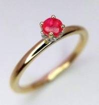 A 9 k yellow gold ring with a ruby standing proud on a halo of diamonds. ring size: O, weight: 2 g.