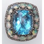 A Mesmerising Blue Topaz, Opal and Diamond Gemstone Ring. Central rectangular blue topaz 20.25ct