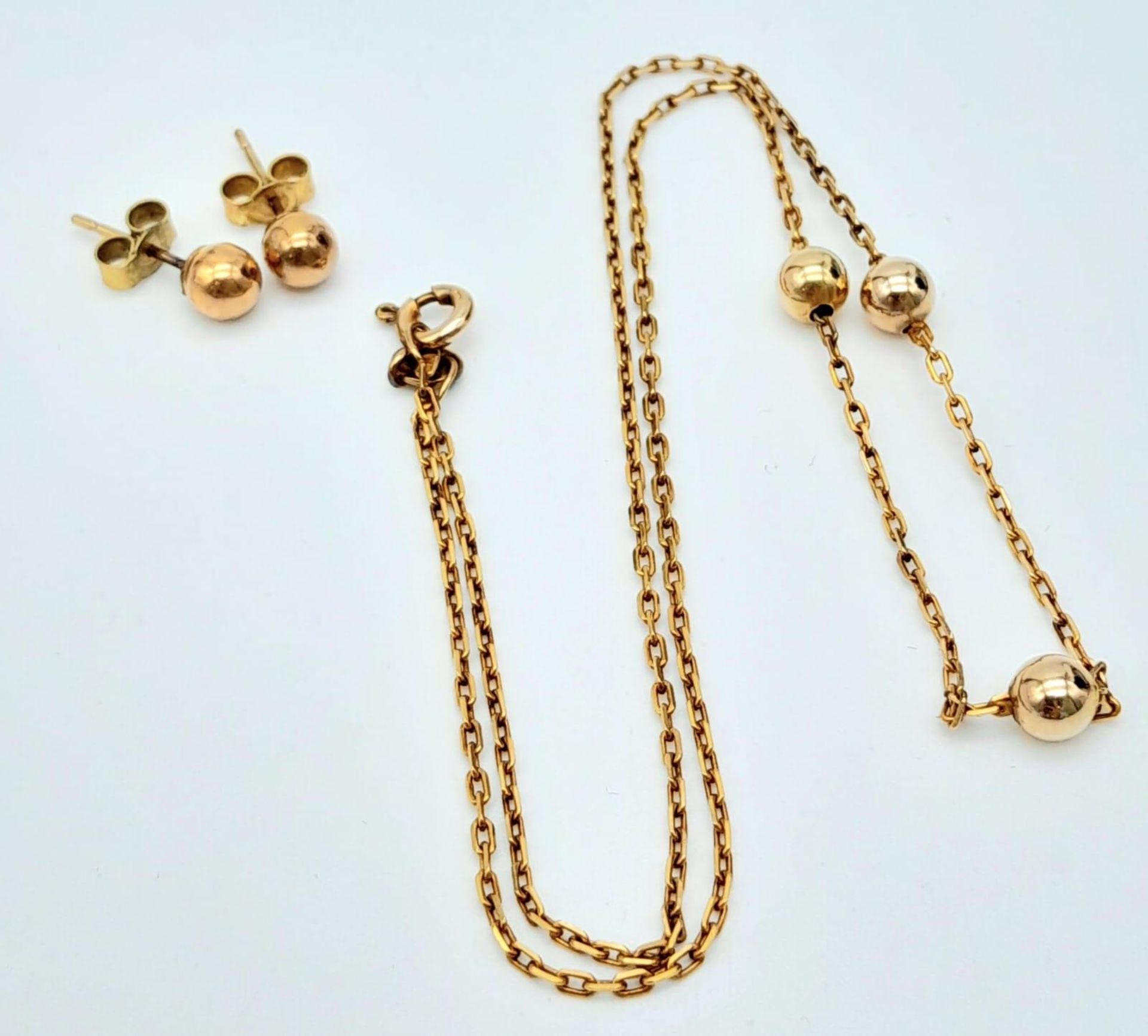 A very attractive, 9 K yellow gold chain necklace with golden balls and a pair of matching earrings.