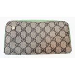 A Gucci Monogram Wallet. Canvas and green leather exterior. Spacious green leather interior with