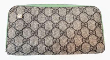 A Gucci Monogram Wallet. Canvas and green leather exterior. Spacious green leather interior with