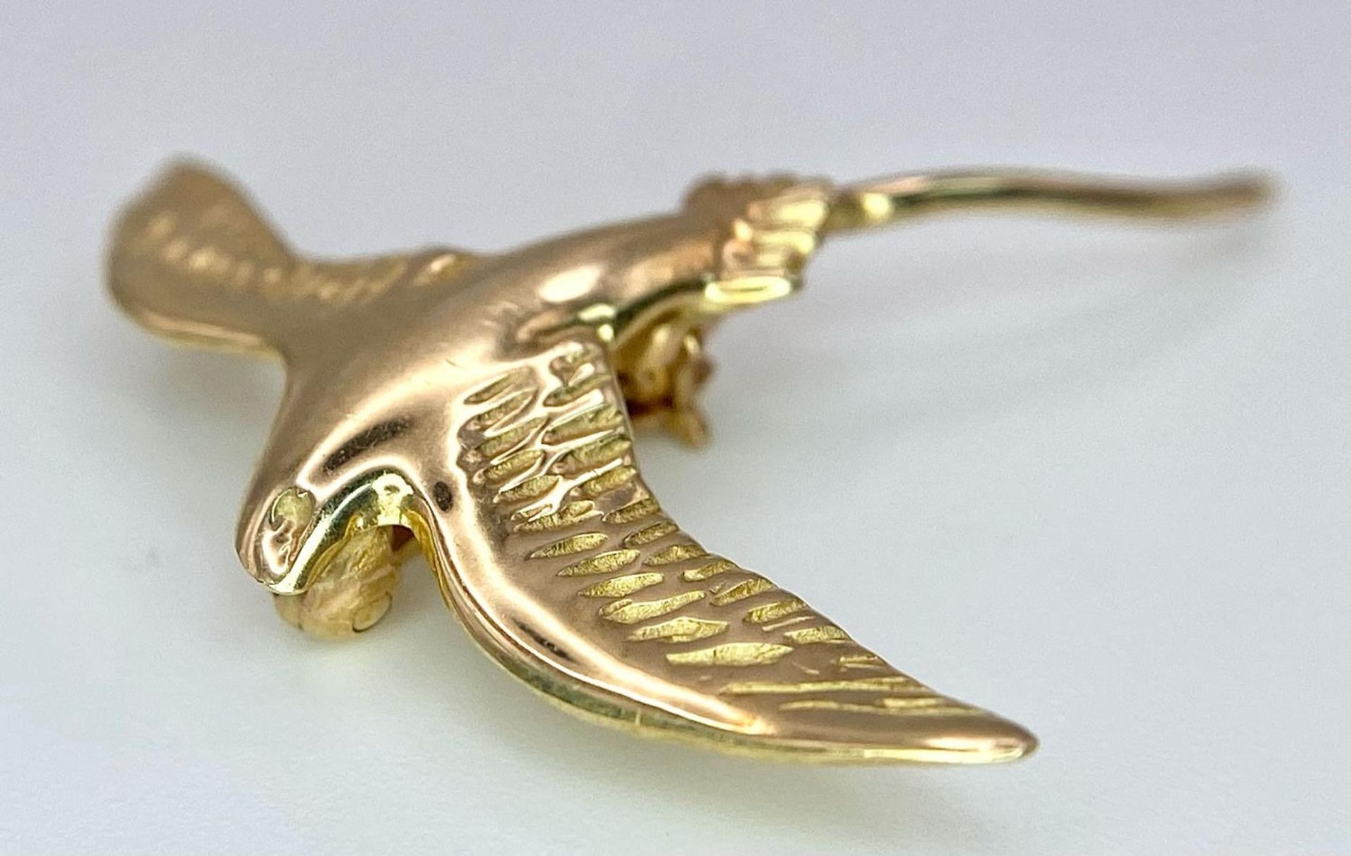 A 14k yellow gold swallow brooch. 3cm X 3cm. 2g