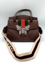 A Gucci Linea Butterfly Clasp Satchel. Brown calfskin leather exterior with decorative white stone