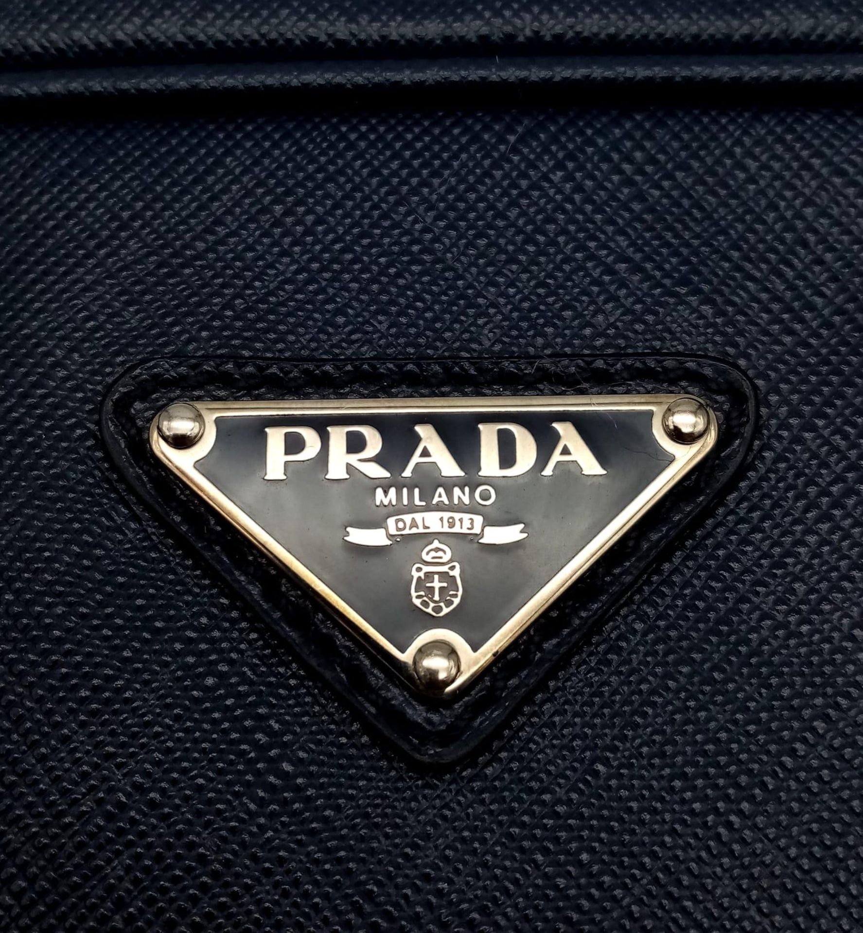 A Prada Saffiano Briefcase. Navy blue textured leather exterior. Prada logo badge. Name tag. Quality - Image 5 of 6