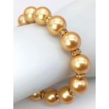 A South Sea Pearl Shell Gold Tone Bead Bracelet. White stone spacers. Gilded clasp. 18cm