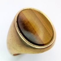 A GENTS 9K GOLD SIGNET RING WITH TIGERS EYE CENTRE STONE . 5.4gms size R