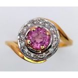An 18K YELLOW GOLD DIAMOND & PINK STONE (BELIEVED TO BE SAPPHIRE) CLUSTER RING. 5G. SIZE L.