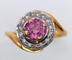 An 18K YELLOW GOLD DIAMOND & PINK STONE (BELIEVED TO BE SAPPHIRE) CLUSTER RING. 5G. SIZE L.