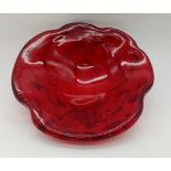A HEAVY RED GLASS ASHTRAY CICA 1960'S POSSIBLY MURANO . 18cms DIAMETER