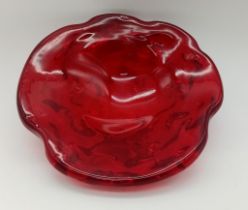 A HEAVY RED GLASS ASHTRAY CICA 1960'S POSSIBLY MURANO . 18cms DIAMETER