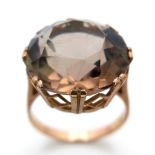 A LARGE SMOKEY QUARTZ FACETED STONE SET IN A 9K GOLD RING . 6.3gms size Q