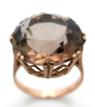 A LARGE SMOKEY QUARTZ FACETED STONE SET IN A 9K GOLD RING . 6.3gms size Q