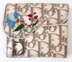 A Christian Dior Wallet. Exterior Dior branding with colourful floral decoration. Two interior