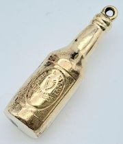 A 9K YELLOW GOLD GUINNESS BOTTLE CHARM. 1.5G