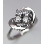 An 18K White Gold Four Stone Diamond Ring. Four brilliant round cut diamonds in a swirl setting.