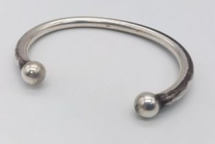 A SOLID STERLING SILVER TORQUE BANGLE. 56.3G