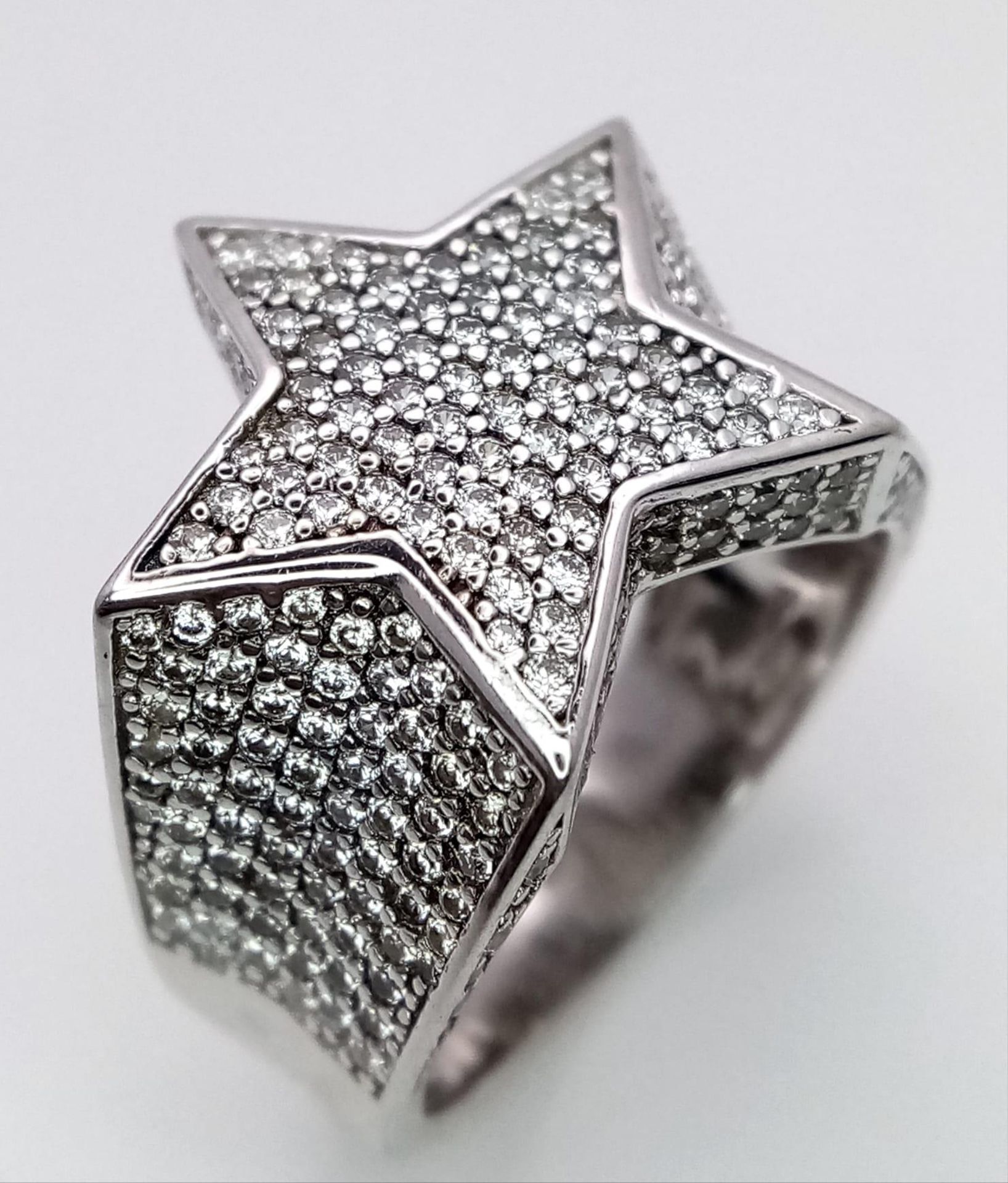 A STERLING SILVER STONE SET STAR RING. 7.9G SIZE S