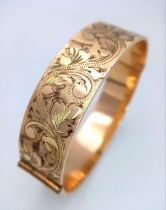 A vintage 50 MICRON 9CT rolled gold click-on bangle with flower motif. Total weight 29.2G.