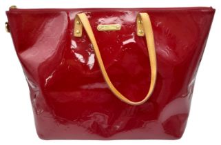 A Louis Vuitton Pomme D'Amour Monogram Vernis Bellevue PM Bag. Red patent leather exterior. Red