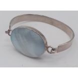 A vintage 925 silver click-on bangle with large Mother of pearl centre. Total weight 22.8G.