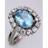 An 18K WHITE GOLD DIAMOND & BLUE STONE (BELIEVED TO BE AQUAMARINE CLUSTER RING 0.60CT DIMAONDS 5.