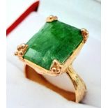 A sterling silver and rose gold ring with an emerald cut emerald (appr. 11 carats). Ring size: O,