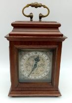 A "ROTHERHAM" CLOCKWORK MANTLE CLOCK WITH ORNATE SCROLLED METAL DIAL . ROMAN NUMERALS AND HOUSED