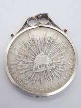 A SOLID SILVER REPUBLIC OF MEXICO COIN DATED 1879 AND IN A SILVER SETTING . 32 5gms