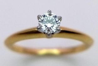 A Tiffany and Co. 18K Yellow Gold Diamond Solitaire Ring. This VVS2 0.19ct brilliant round cut