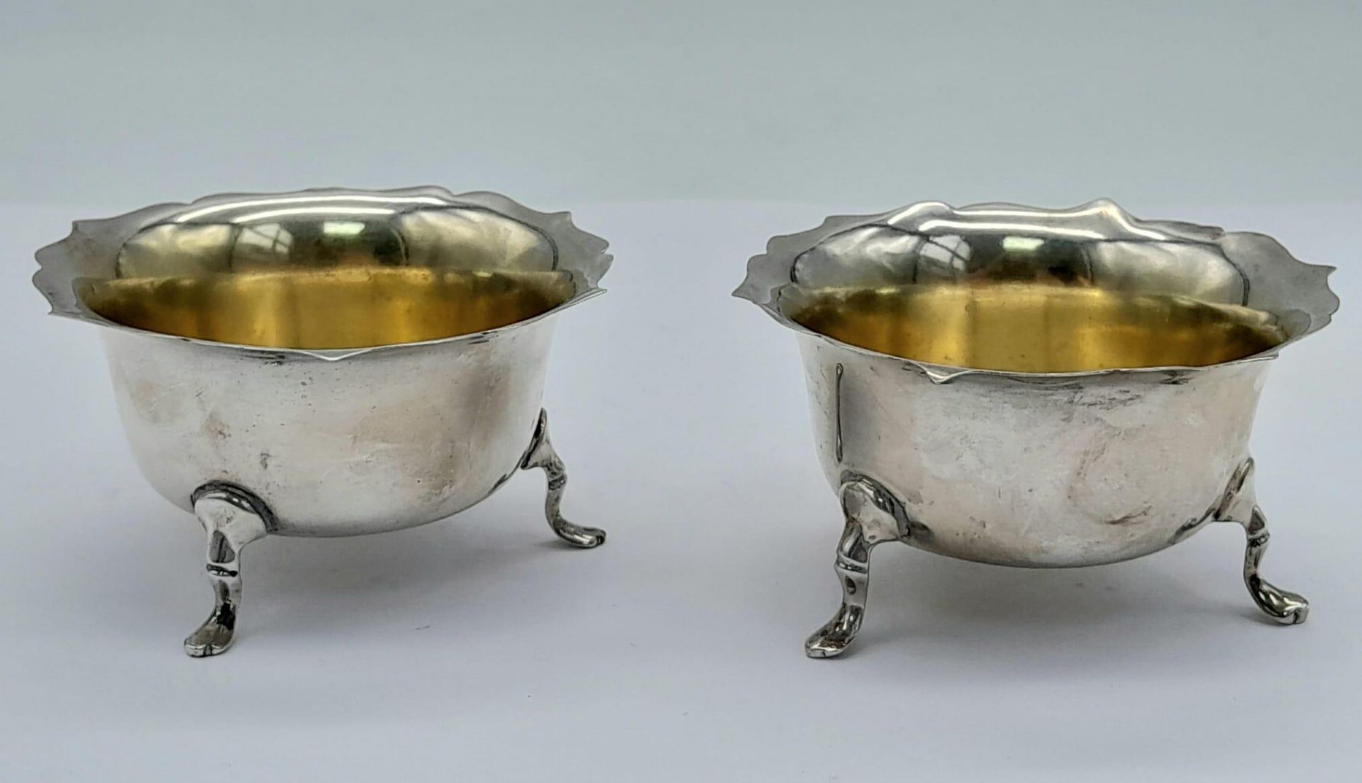 A PAIR OF FOOTED SILVER SALTS WITH GILDED INTERIOR DATED 1919 BIRMINGHAM . 46.2gms 6cms DIAMETER