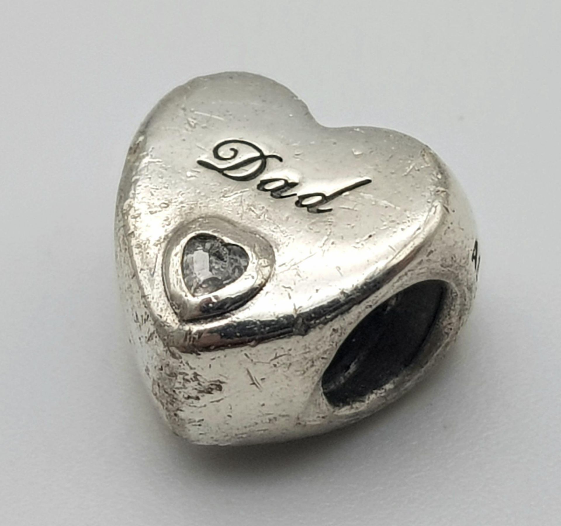 A PANDORA STERLING SILVER HEART SHAPED STONE SET CHARM, ENGRAVED WITH THE WORD "DAD" 3.9G ref: SC - Image 5 of 7